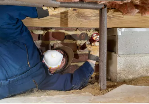 A tech performs work in a crawl space. Basement Systems Waterproofing & Foundation performs Crawl Space Encapsulation in East Peoria IL.