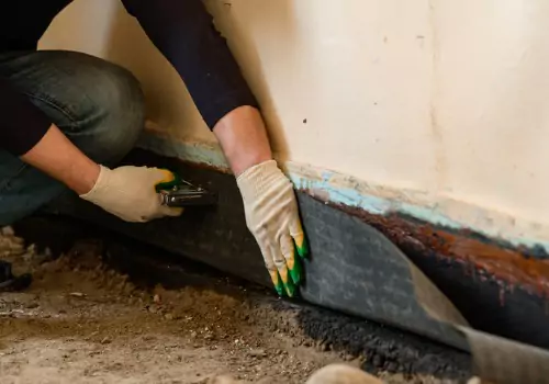 A tech performs foundation waterproofing. Heartland performs Foundation Waterproofing in East Peoria IL.